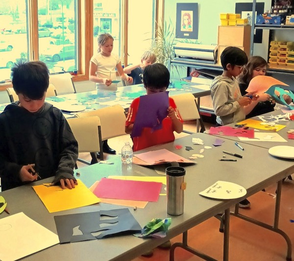 Children cutting paper during workshop